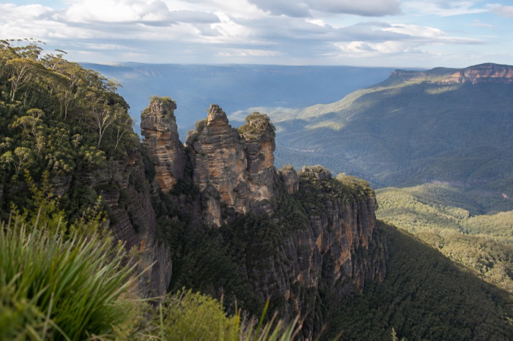 The Three Sisters rock formation viewed across a wide forested valley