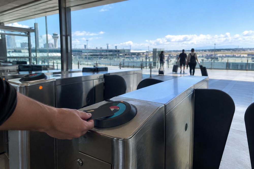 A contactless credit card tapping on at an Opal reader on a train station gate