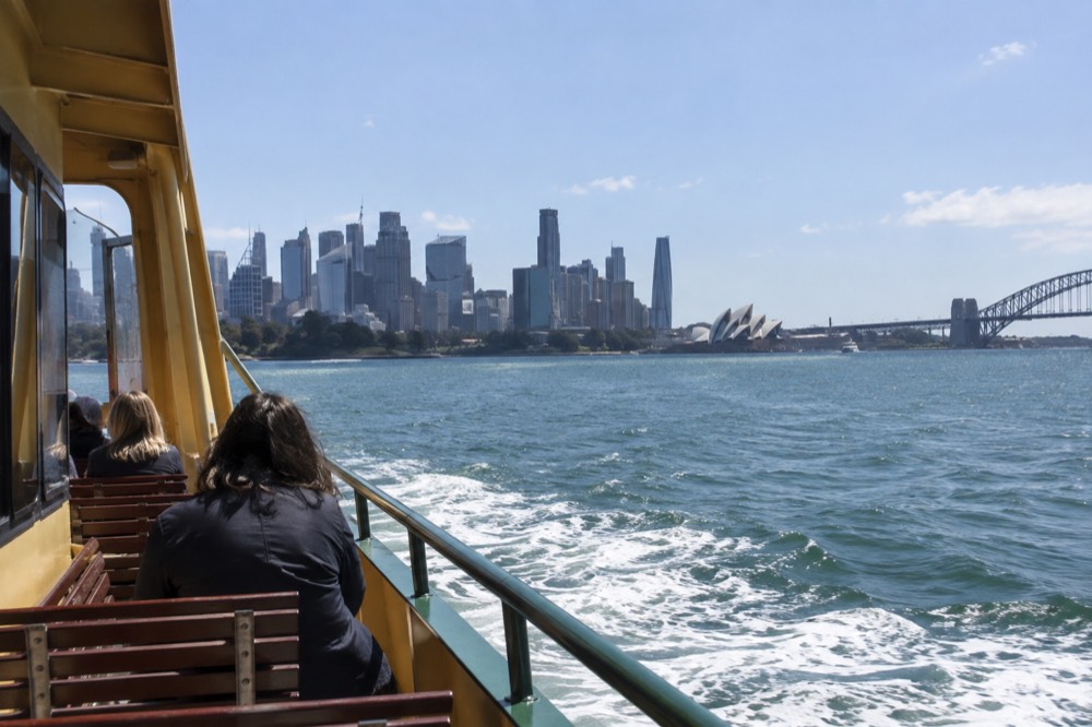 Ferry crossing Sydney Harbour towards the city skyline on a clear afternoon