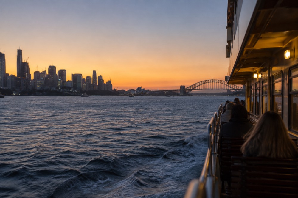 Ferry crossing Sydney Harbour with the city skyline behind it