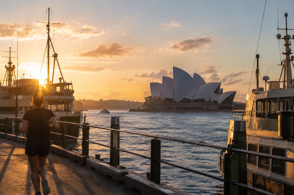 The Sydney Opera House sails rising above the harbour, with ferry masts in the foreground