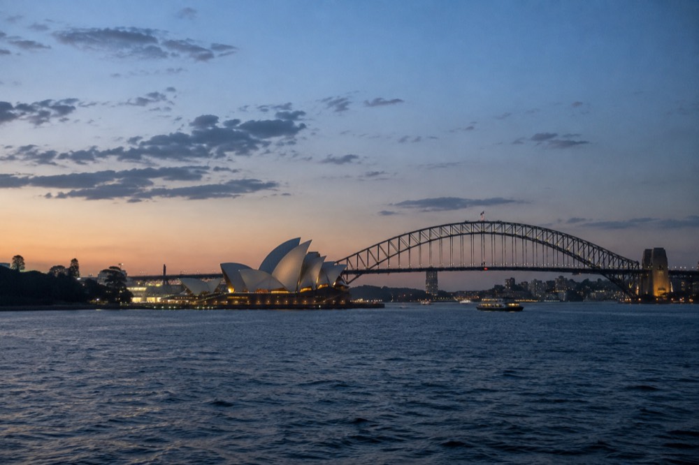 Sunlight on the Opera House sail roofs with the harbour bridge in the distance