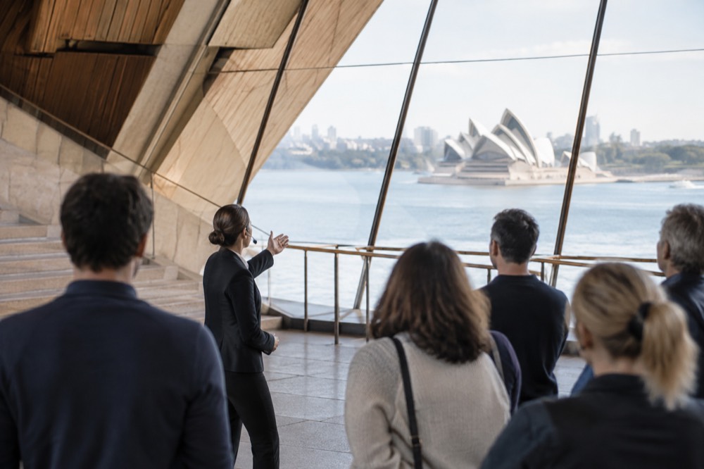 A guide leading a small group through the brightly lit interior of the Sydney Opera House