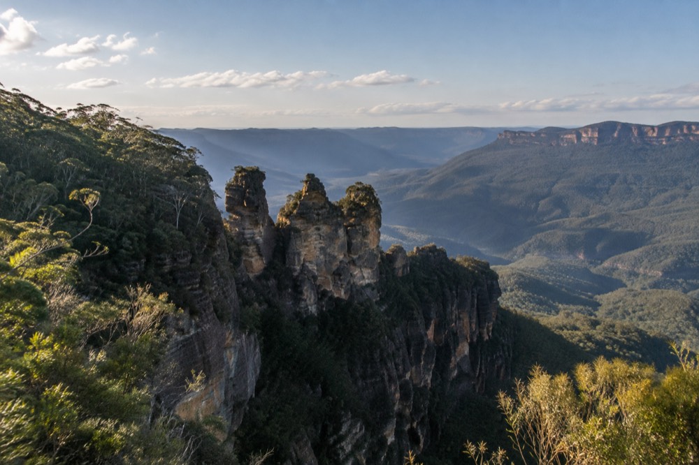 The Three Sisters rock formation at Katoomba seen across a forested valley