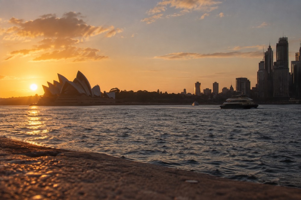Sunset light on Sydney Harbour with the Opera House and city skyline silhouetted