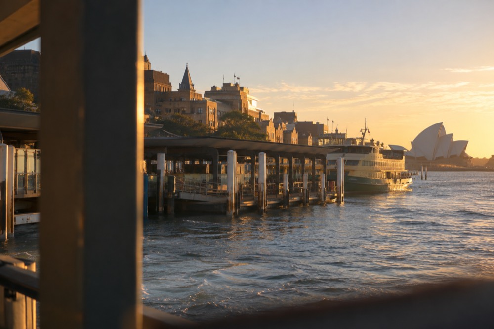 Ferry wharves at Circular Quay in the late afternoon with the sandstone buildings of The Rocks behind them