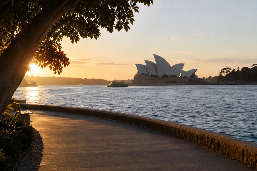 Empty harbourside walkway in Sydney with the Opera House in soft winter light