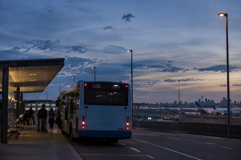 A Sydney commuter bus at a shelter near the airport precinct