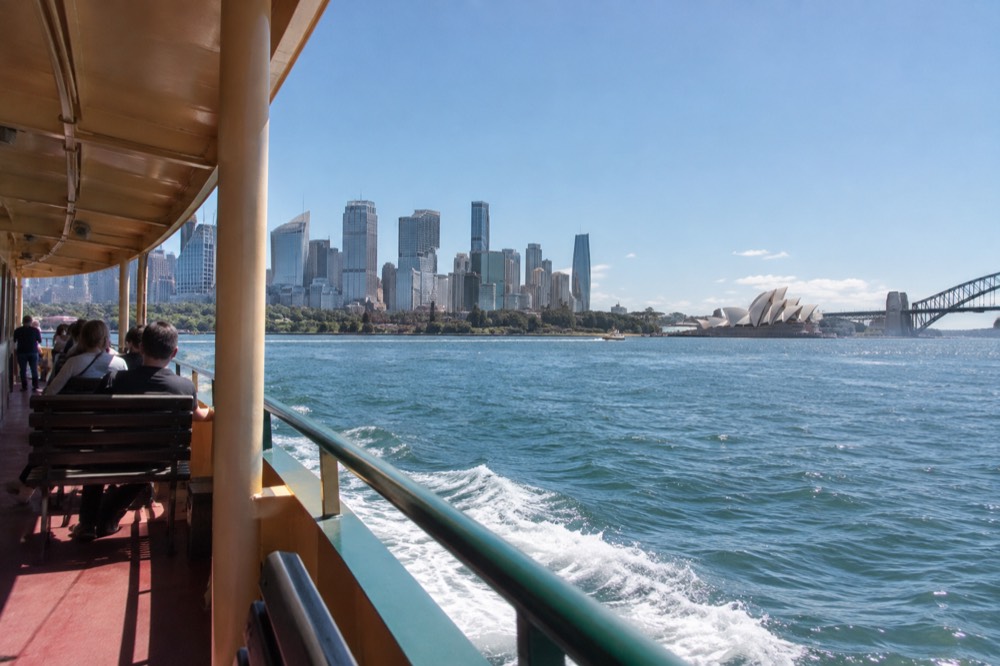 A public ferry crossing Sydney Harbour with the city skyline behind it
