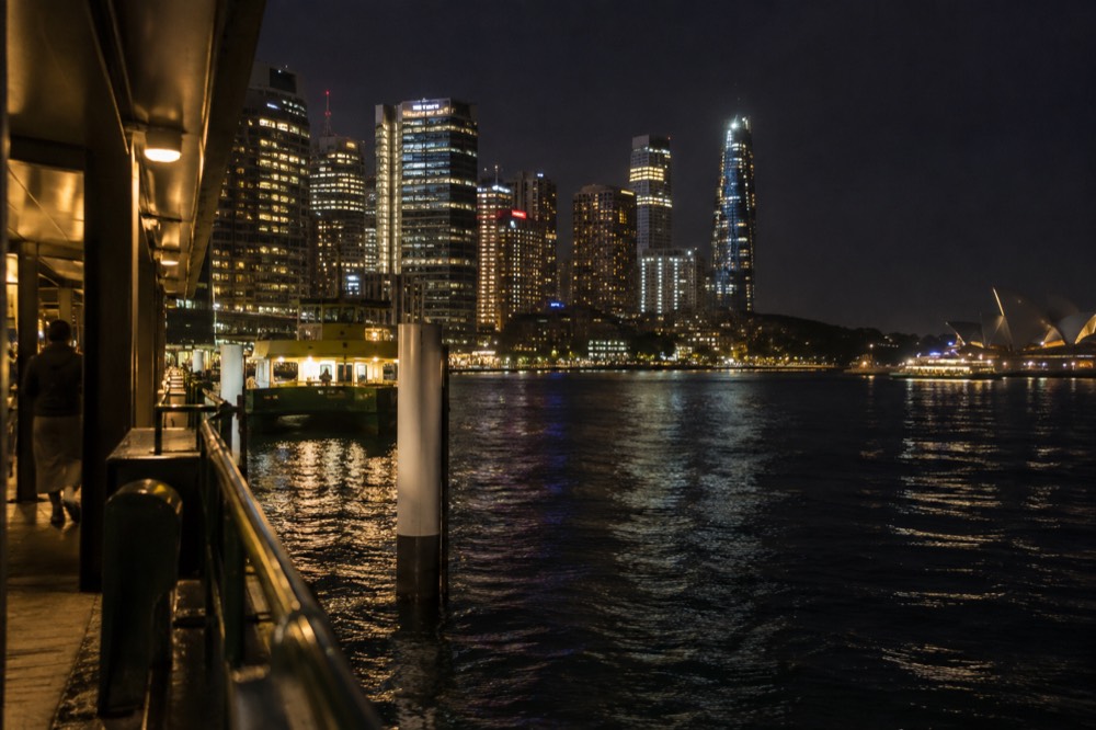 Sydney city skyline illuminated at night seen from the harbour bridge roadway