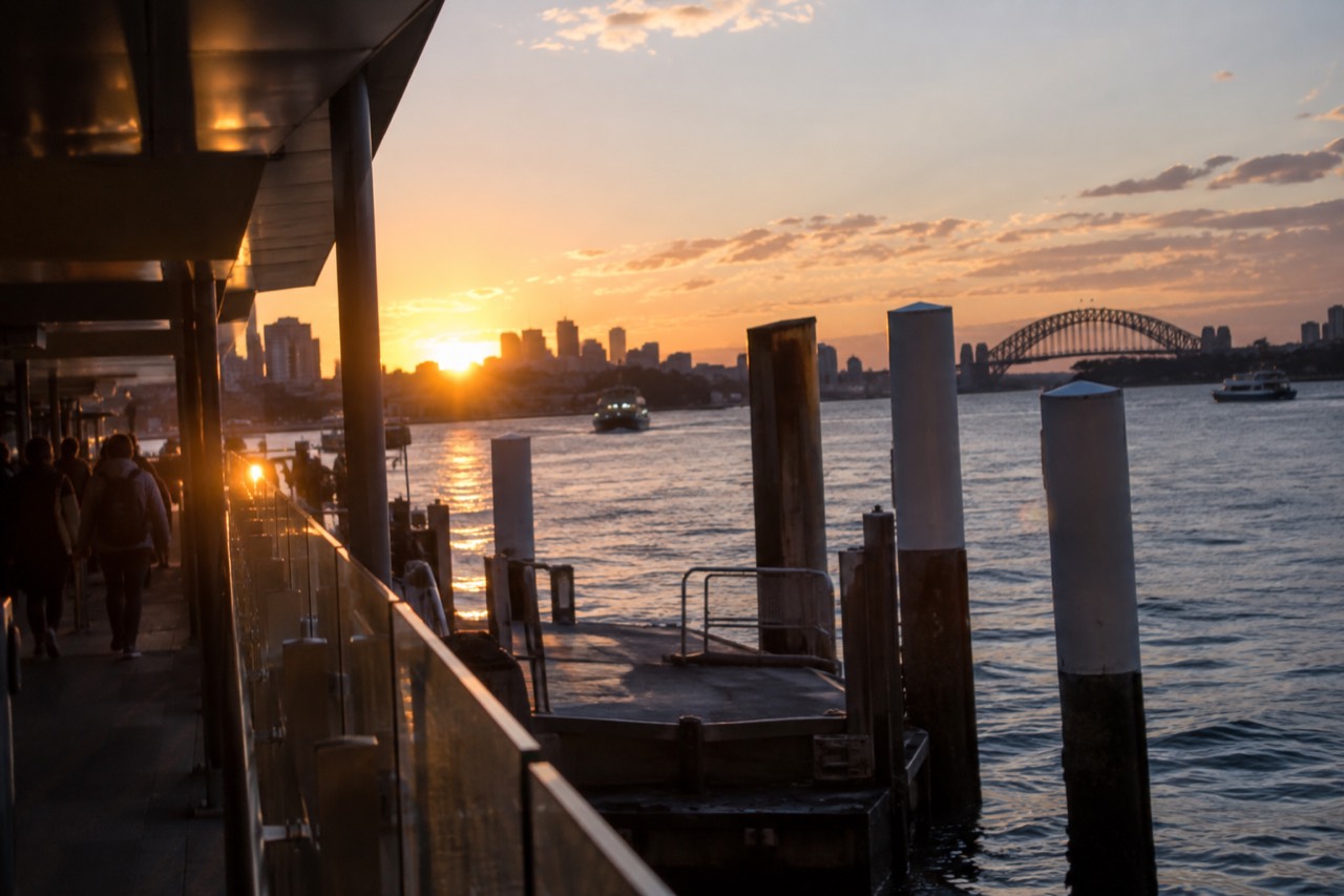 Sydney Harbour at dusk with city lights reflecting on calm water