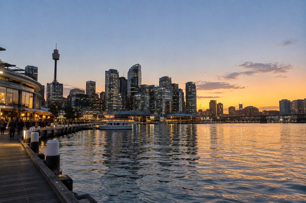 Evening view across Darling Harbour toward city towers and waterfront restaurants