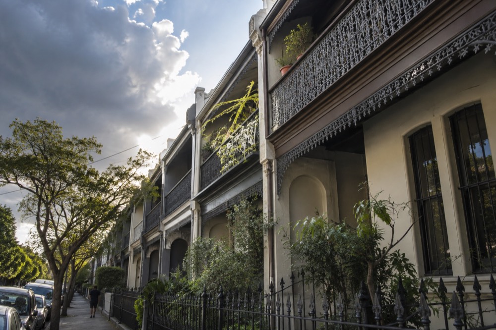 A row of Victorian terrace houses with iron lace balconies in an inner Sydney street