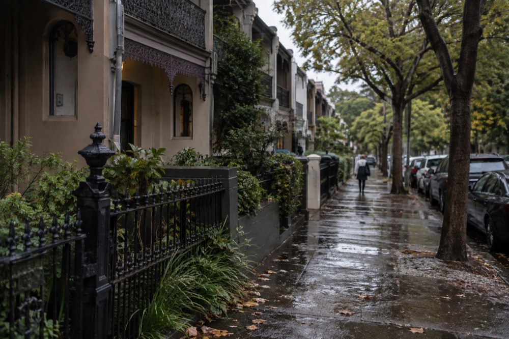 Terrace houses with iron lace balconies along a tree-lined inner west street
