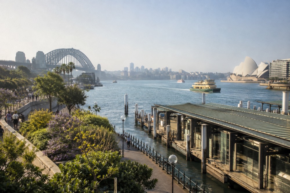 Garden paths and harbour water with the city skyline in the distance
