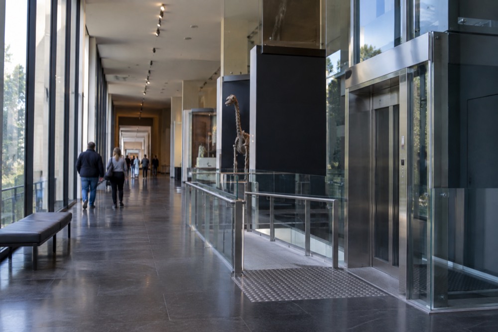 A wide museum corridor with a lift and step-free access to gallery floors