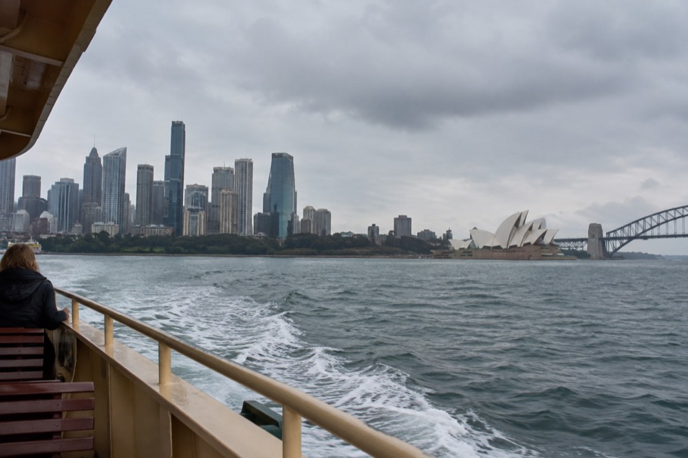 Ferry crossing Sydney Harbour with the city skyline and Opera House behind it