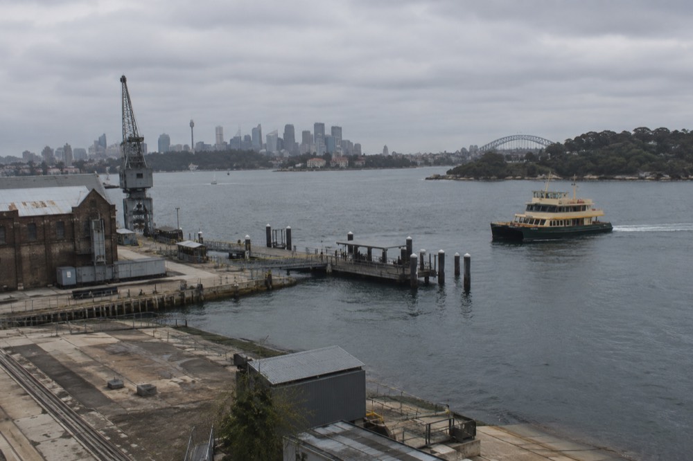 Ferry wharf on the island with a vessel approaching across open harbour water