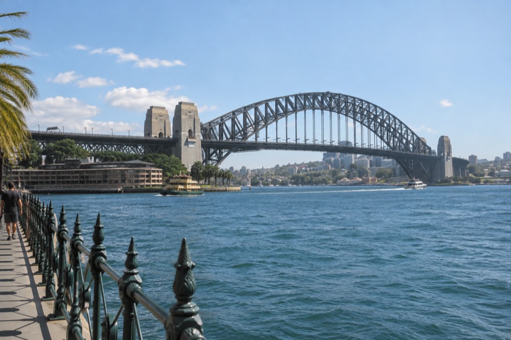 The sandstone pylons of the Sydney Harbour Bridge seen from the Circular Quay foreshore on a clear morning