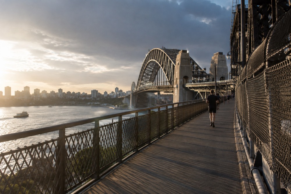 The arch and northern pylons of the Sydney Harbour Bridge seen along the bridge structure from the southeast pylon