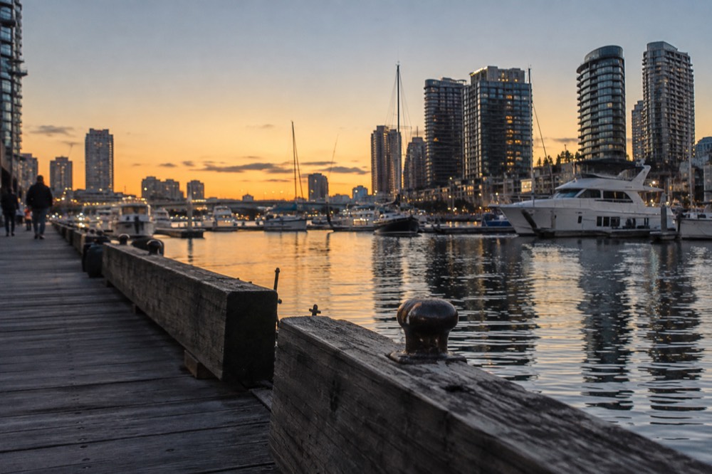 Darling Harbour boardwalk with moored boats and apartment towers on a bright afternoon