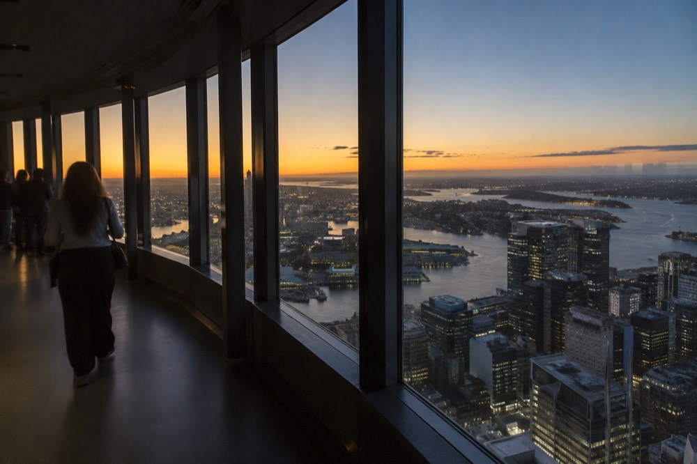 Observation deck interior with floor-to-ceiling windows overlooking city buildings