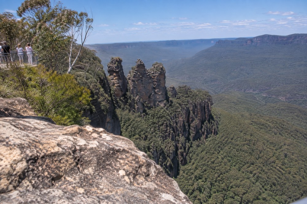 The Three Sisters rock formation viewed across a forested valley from Echo Point