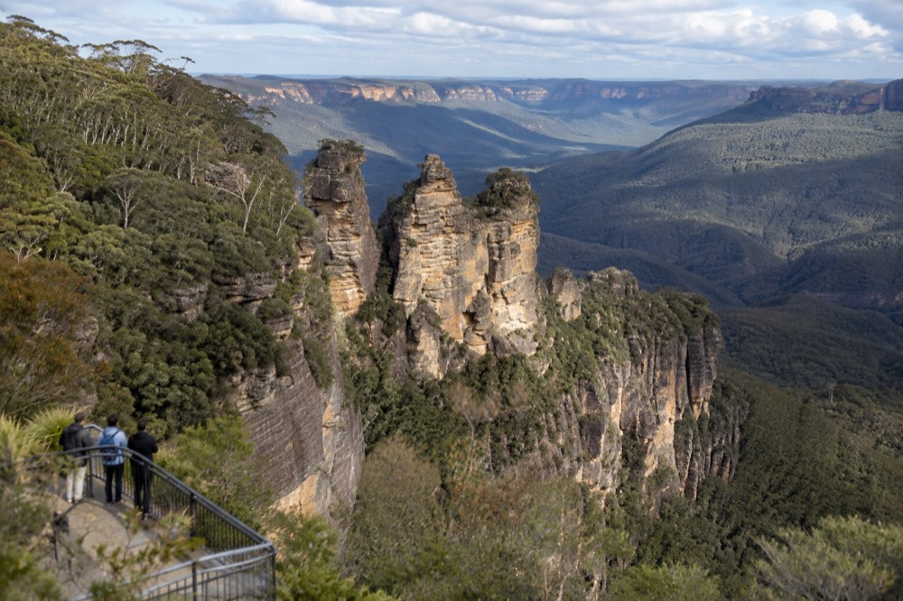Three sandstone pillars rising above a eucalypt forest valley