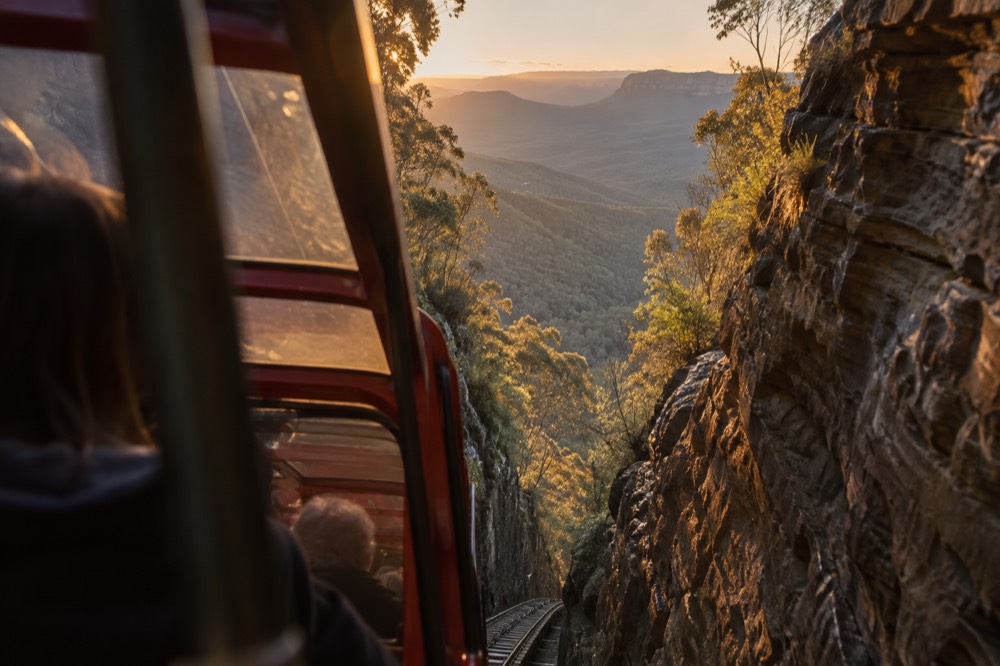 Railway carriage descending a steep cliff cutting through sandstone
