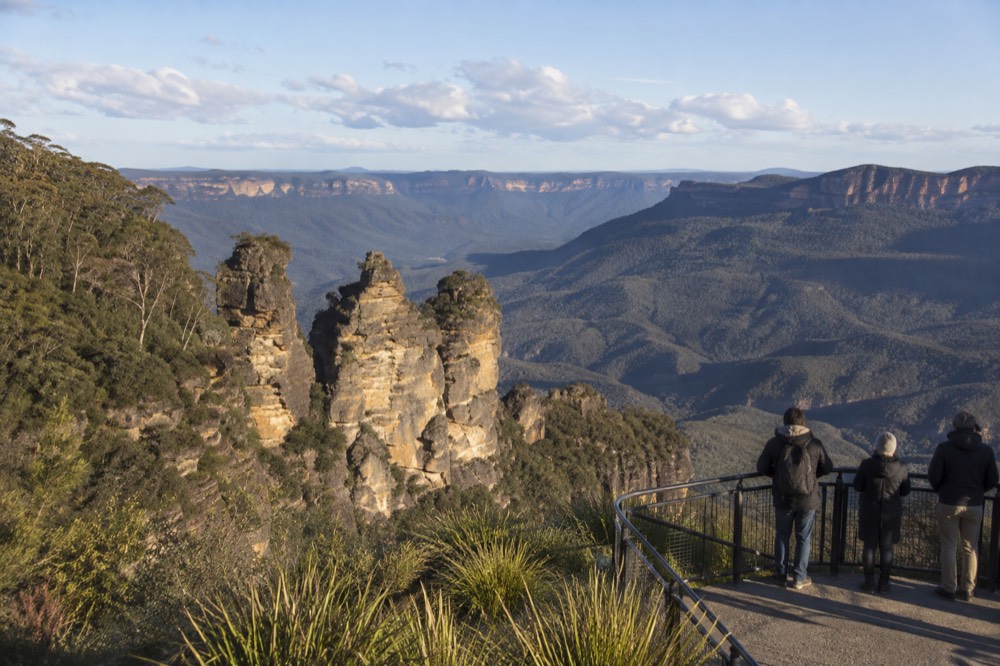 Sandstone rock formations standing above a wide valley in late afternoon light