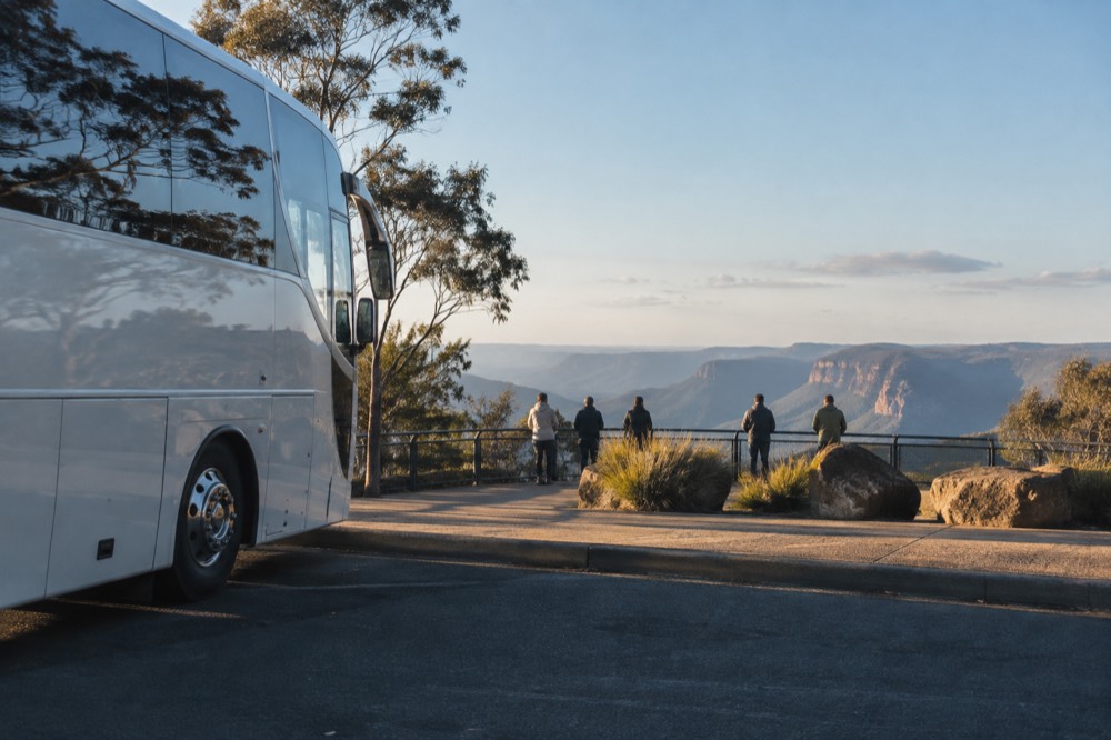 A coach parked at a Blue Mountains lookout with a paved viewing platform overlooking the valley