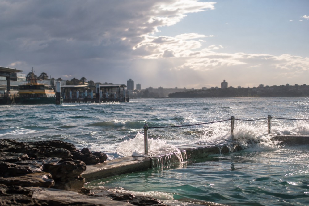 Ocean pool at the south end of a Sydney beach with waves breaking over the edge and no swimmers