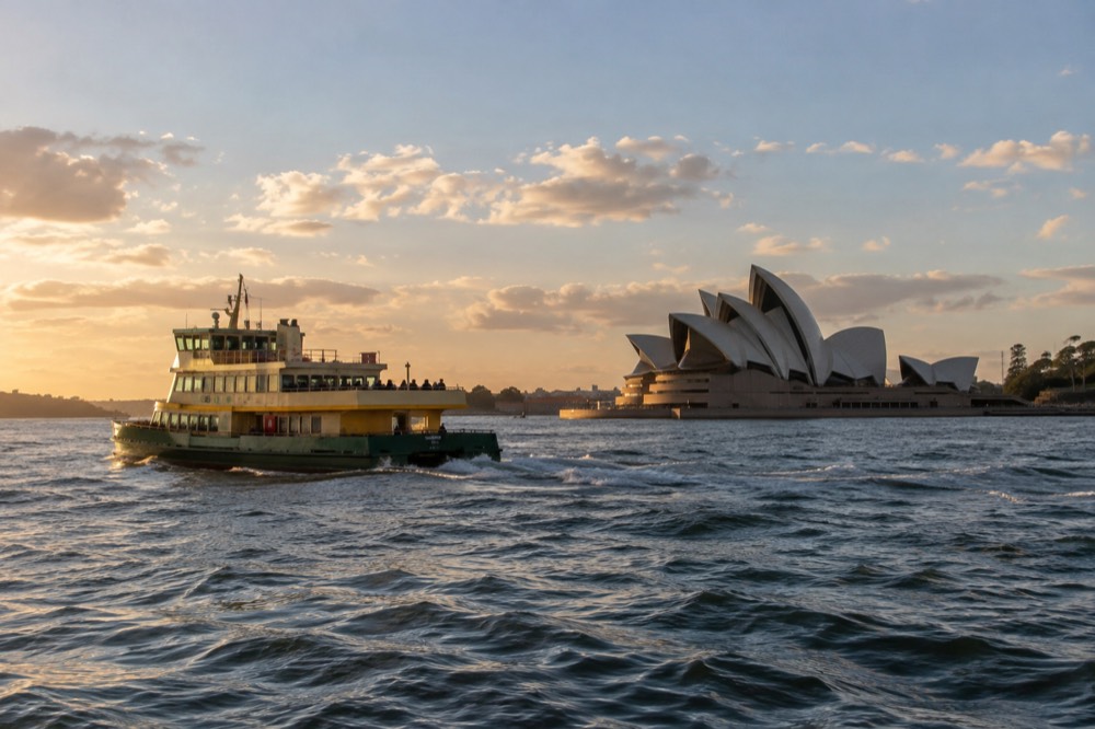 A harbour ferry passing the Sydney Opera House in late afternoon light