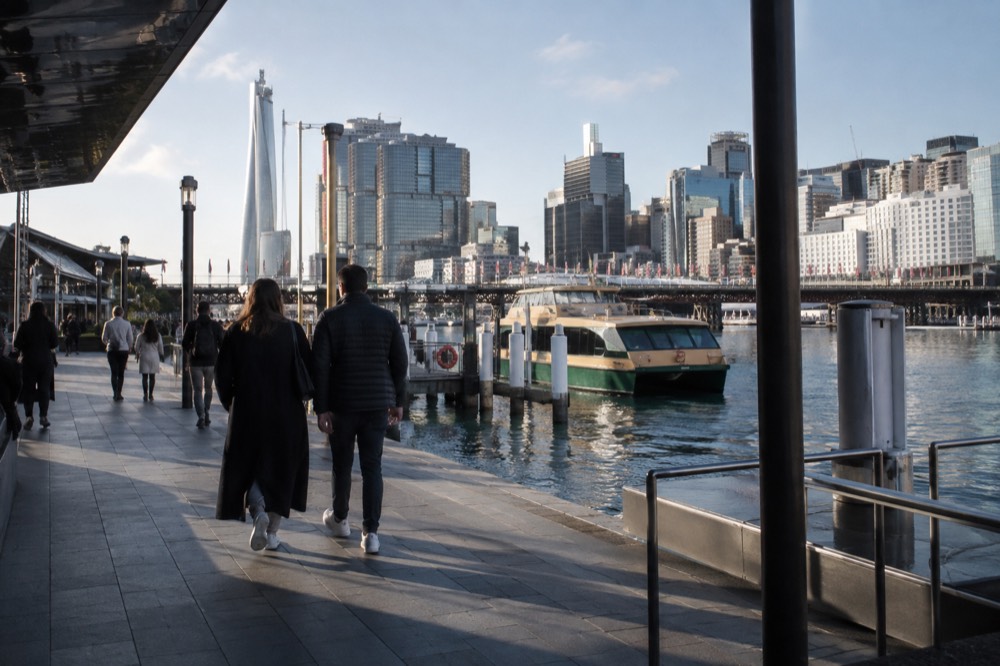 Darling Harbour waterfront walkway with ferry and city buildings behind