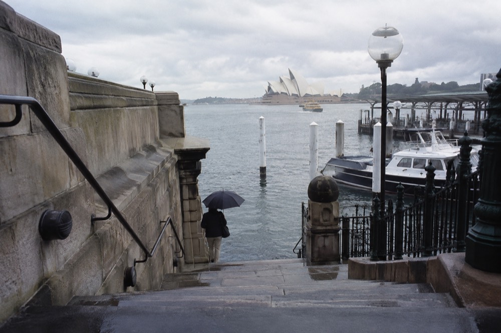 Quiet sandstone staircase leading down to a small harbour cove with moored boats