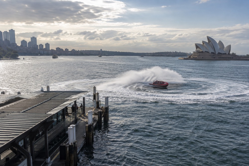 Spray rising over the stern of a jet boat during a spin on open harbour water