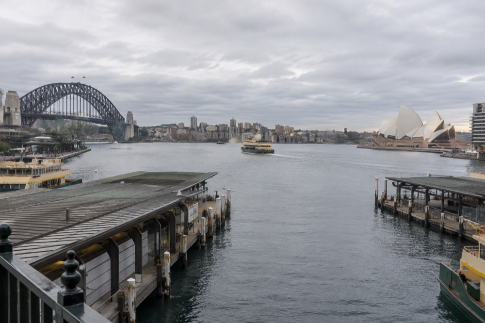 Calm early morning water on Sydney Harbour with the city skyline in soft light