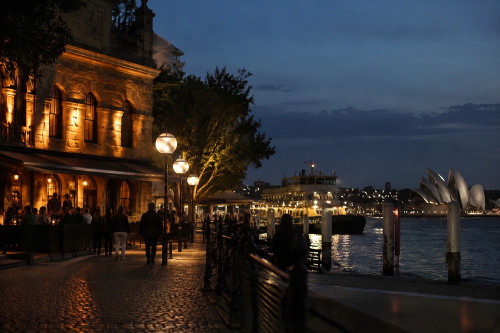 A historic sandstone pub illuminated at dusk on a cobblestone street