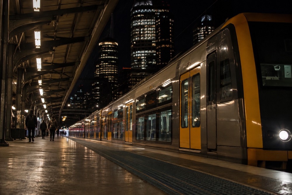 A lit train platform at night with a city train waiting at Central Station