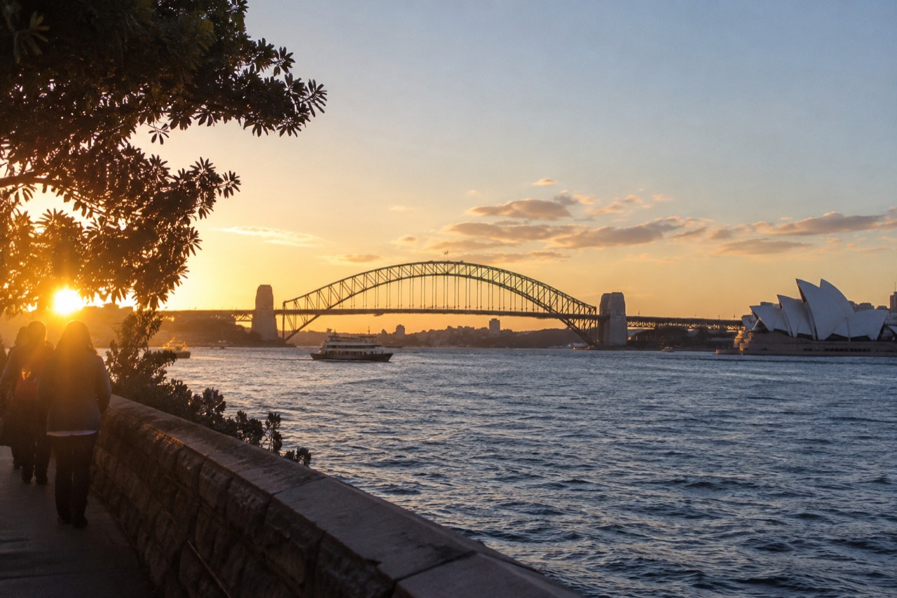 Sydney Opera House and Harbour Bridge seen across the water at golden hour