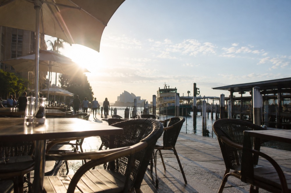 Outdoor cafe tables along a city street in morning light