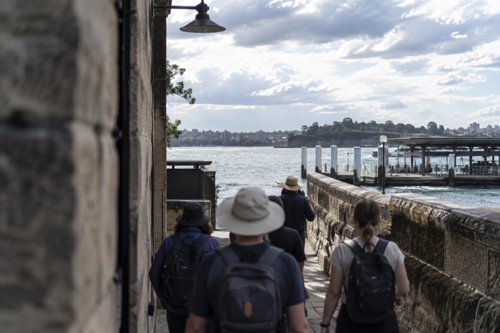 A small group of walkers following a guide along a narrow historic lane