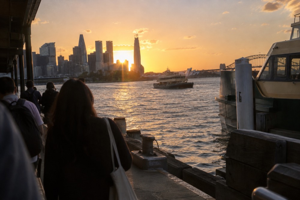 Sunset behind the Sydney skyline seen from Barangaroo with orange light on the water