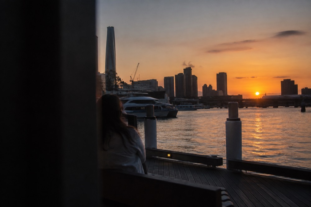 Long evening shadows across Darling Harbour with the sun low over the western skyline