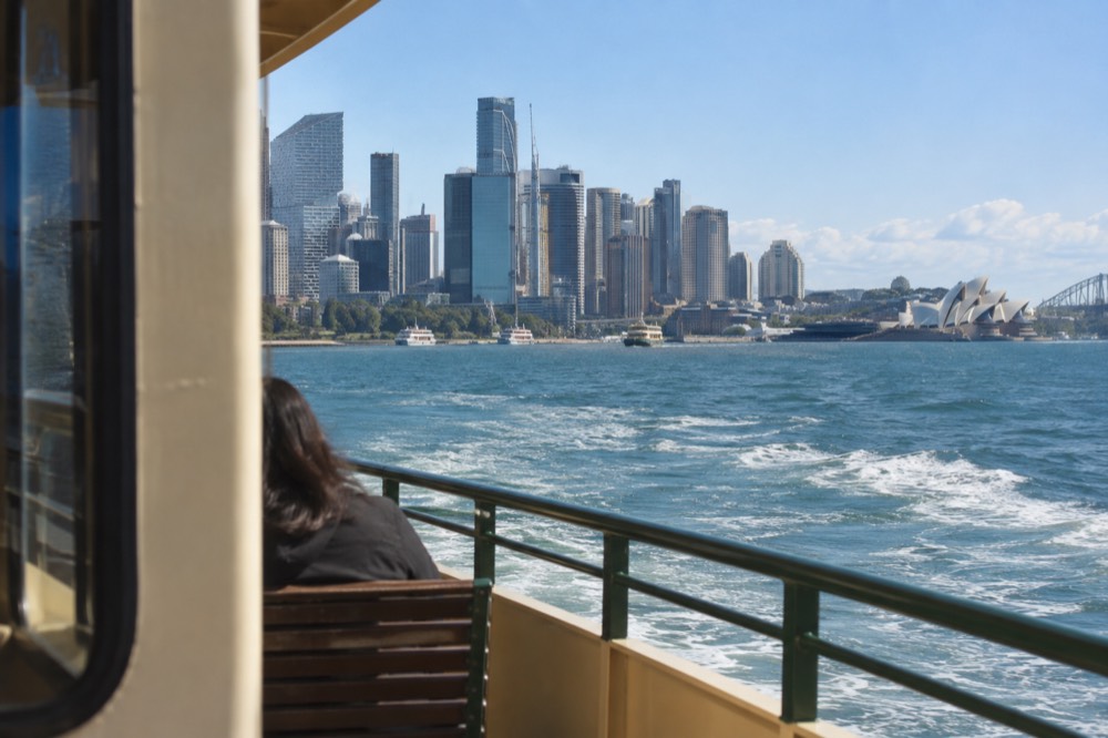 Ferry crossing Sydney Harbour with the city skyline behind it