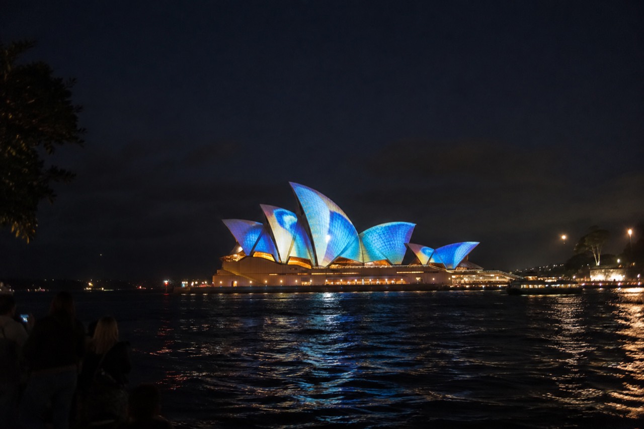 Illuminated projections washing over the Sydney Opera House sails at night during a light festival