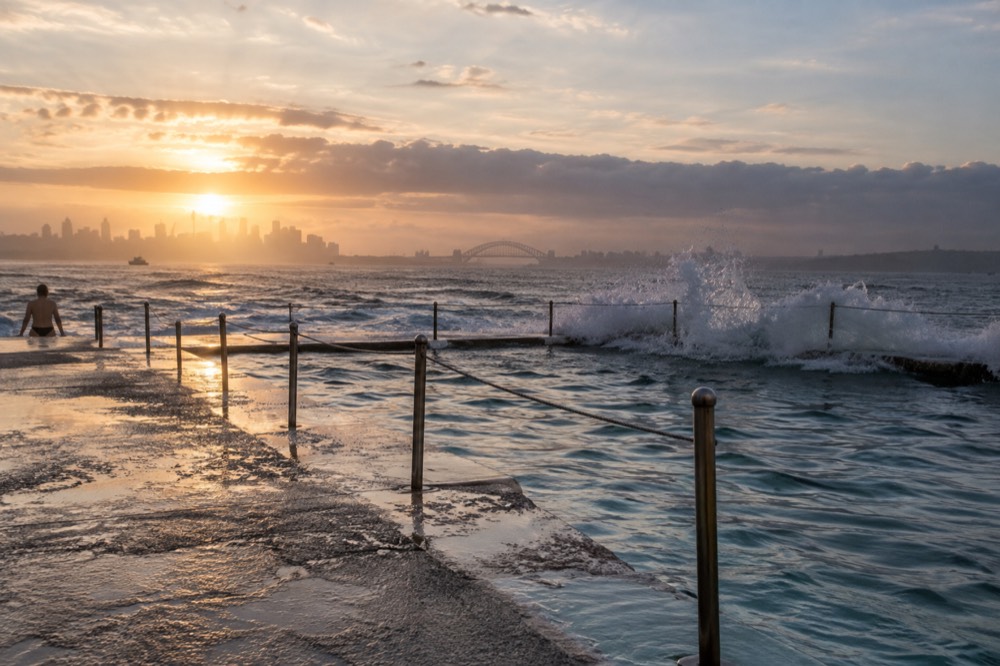 Ocean waves breaking along a Sydney ocean pool at sunrise