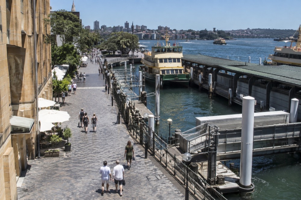 Sandstone terrace buildings and cobbled laneway in a historic waterfront district