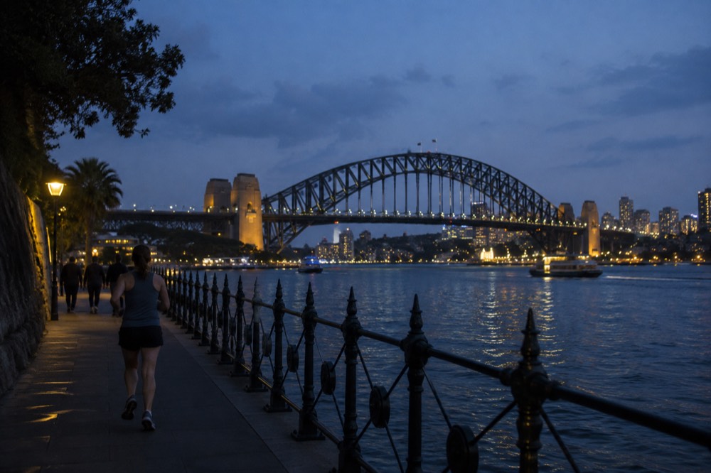 Evening city skyline and harbour bridge lights reflecting on dark water