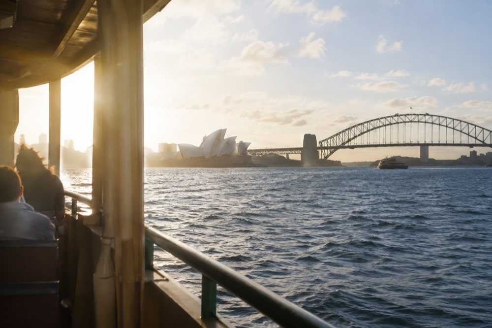 Ferry crossing Sydney Harbour with the Opera House and Harbour Bridge in the background